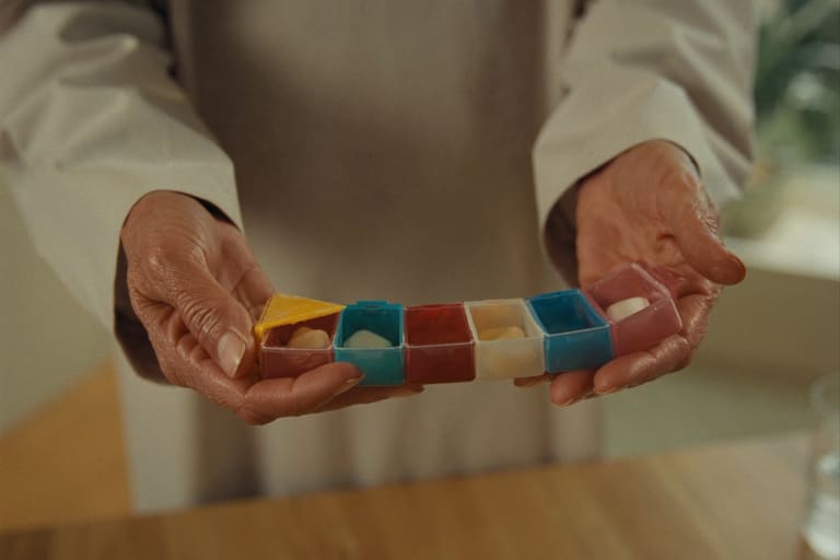 Les mains d’un patient qui tiennent un pilulier