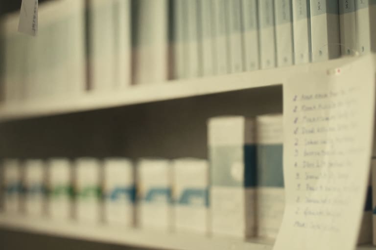 Des rayonnages de médicaments et une fiche de processus écrite à la main